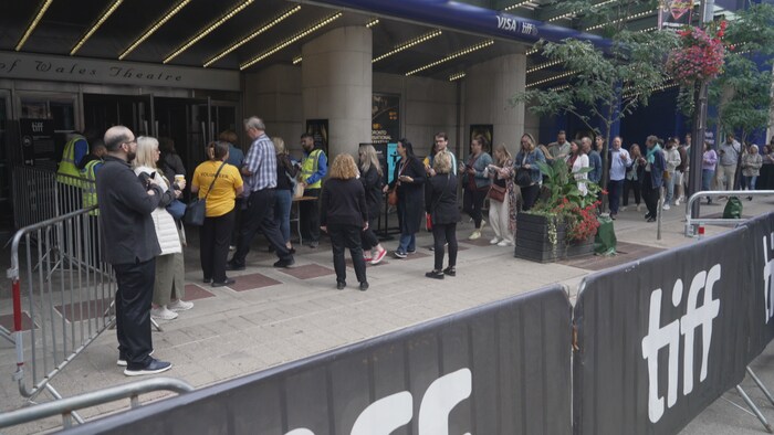Des gens attendent en record  devant le théâtre Princess of Whales.
