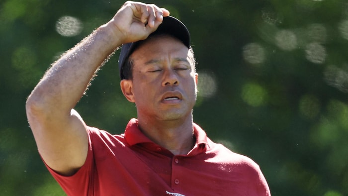 Tiger Woods, les yeux fermés et l'air découragé, relève sa casquette.