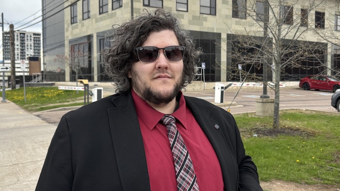 Un homme portant une chemise rouge près du palais de justice de Moncton. 