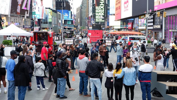 Des visiteurs déambulent sur Times Square. 