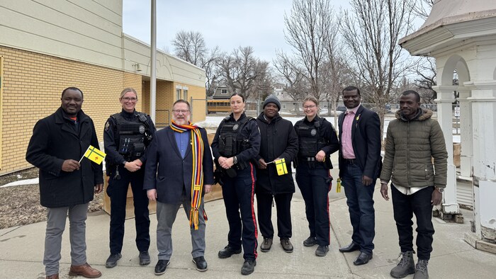 Un groupe de personnes en face du drapeau fransaskois