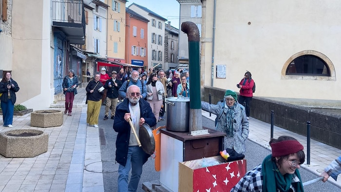 Un groupe de personne défilent avec des casseroles dans les rues de Florac.