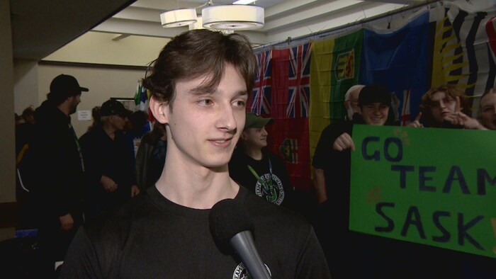 Cameron Krueger enentrevue, alors qu'on voit des gens derrière lui, le 30 mars 2025 à Saskatoon. 