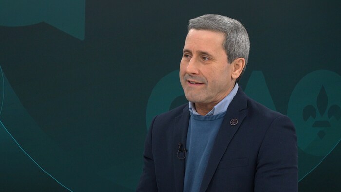 Un homme discute sur un plateau de télé.