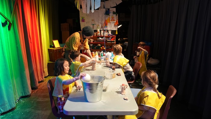De jeunes enfants font du bricolage avec un adulte.