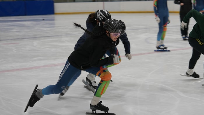 Une jeune patineuse de vitesse en pleine course.