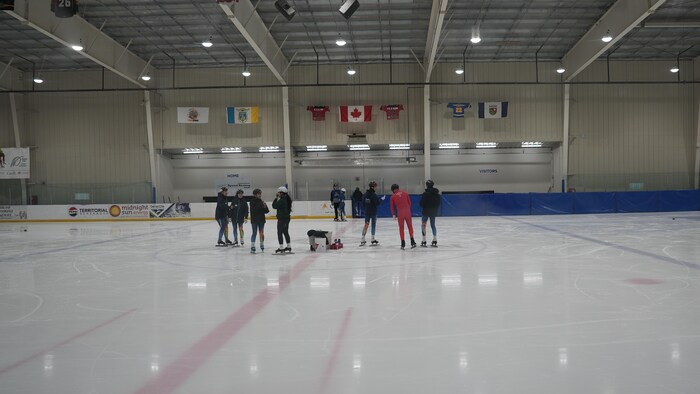 Des patineurs au milieu d'une patinoire.