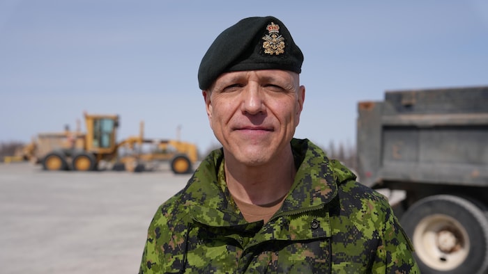 Daniel Rivière, en uniforme, devant de la machinerie lourde, le 24 avril 2024, à Yellowknife.