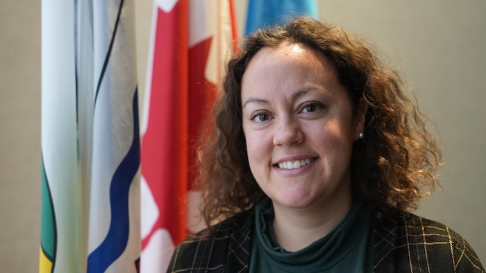 Rebecca Alty devant des drapeaux, le 16 décembre 2024, à Yellowknife.