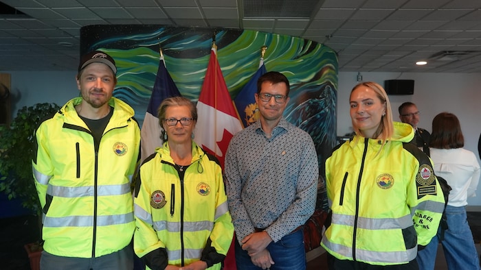 Bill Peck accompagné de trois bénévoles de l'équipe de recherche et sauvetage de Yellowknife en uniforme. 