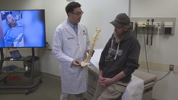 Dr. Michael Yang, the Calgary surgeon who performed the procedure, speaks with his patient, Todd Bene. (Dave Gilson/CBC)