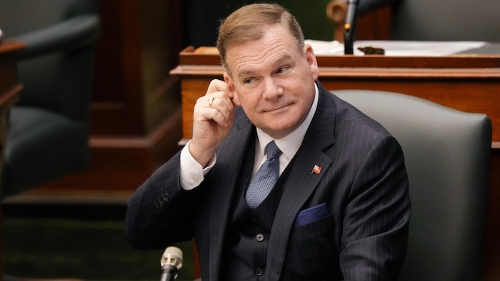 Todd McCarthy se gratte l'oreille assis à son bureau dans l'Assemblée législative.