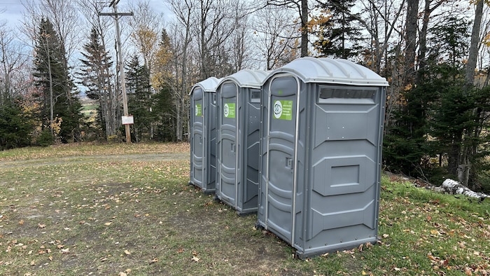 Trois toilettes sèches sont disposées à l'extérieur.