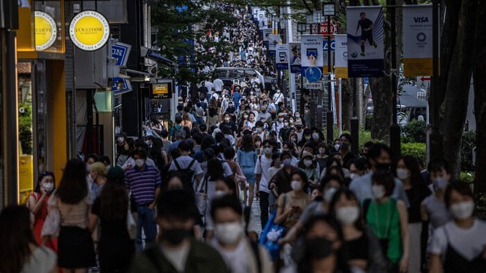 Une foule déambule dans une rue de Tokyo.