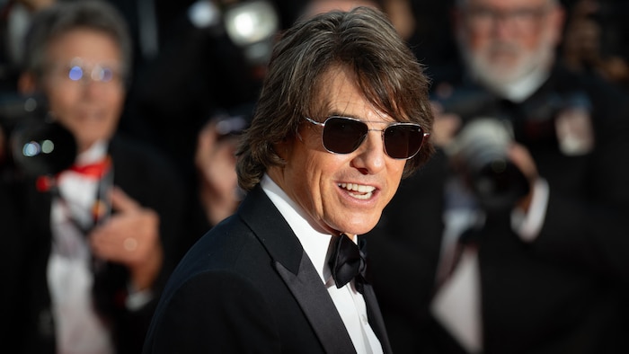 L'acteur airs sur un tapis rouge, portant des lunettes de soleil.