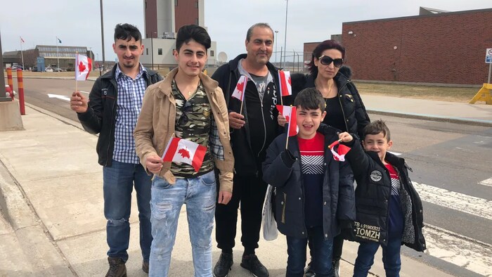 The Toma family pose outside the airport shortly after their arrival in 2018. The boys were ages 6-18 when they arrived. 