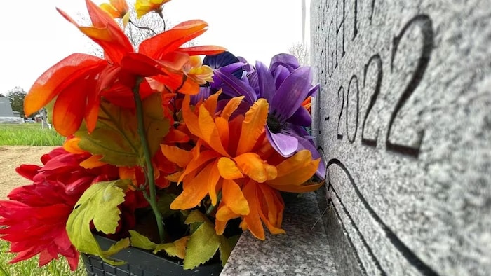 Une pierre tombale et des fleurs.
