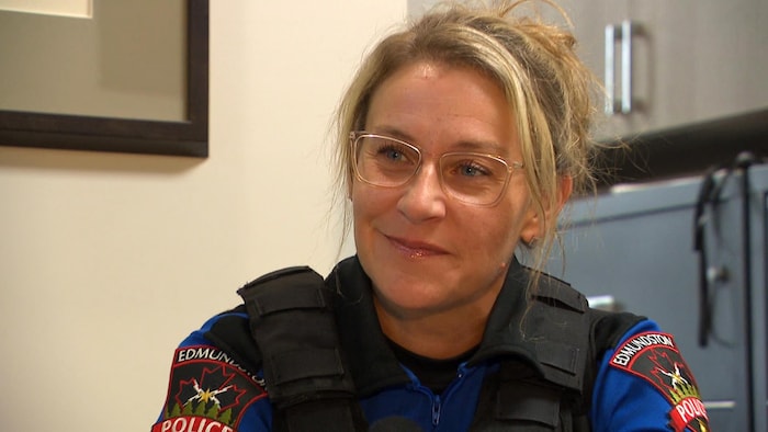 Une policière interviewée dans un bureau.