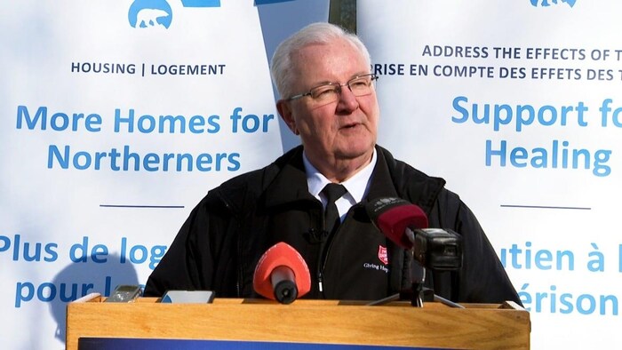 Tony Brushett devant des micros lors d'une intervention sur le logement.