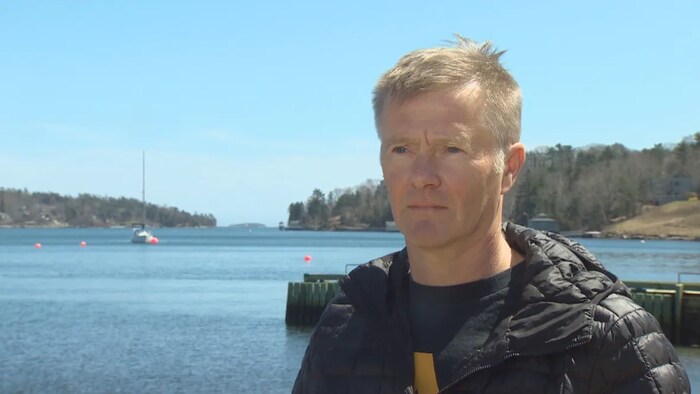 Tony Walker debout devant un quai.
