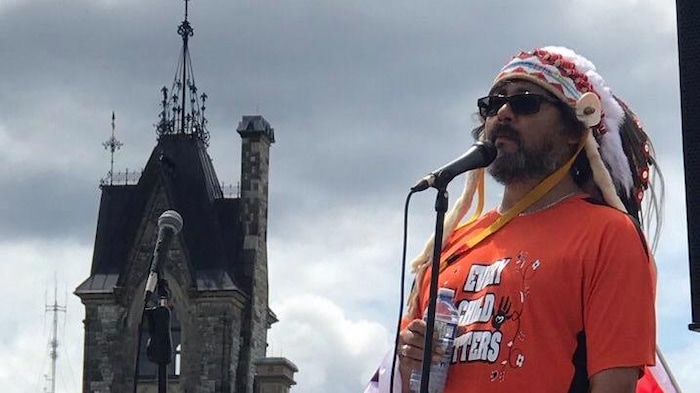 El jefe indígena Tony Wawatie, de la comunidad algonquina de Lac-Rapid habla ante el micrófono frente al Parlamento de Canadá.