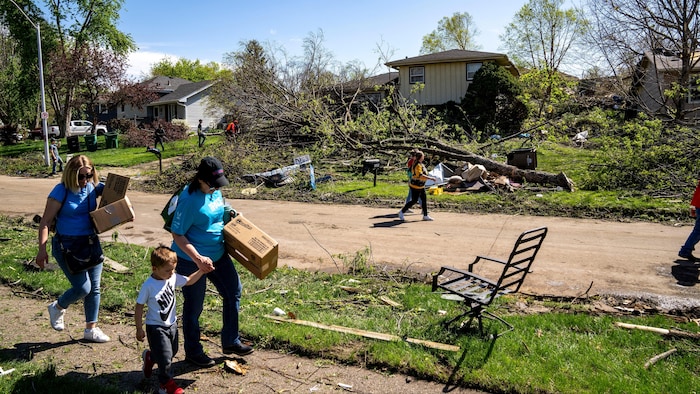 Des habitants nettoient les débris dans la banlieue de Des Moines, à Pleasant Hill, après que de nombreuses tornades eurent traversé l'Iowa.