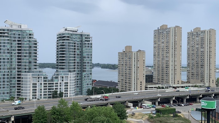 سيارات تمر على طريق غاردينر السريع المرتفع في تورونتو، مع أبراج سكنية في الخلفية.
