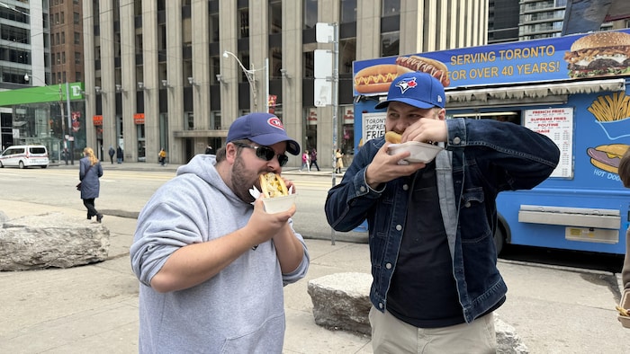 Gabriel Schultz mange un hot-dog avec son ami