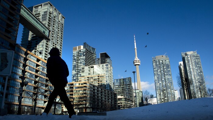 Un passant dans un quartier de tours à Toronto.