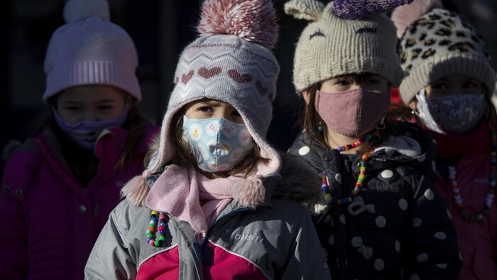 De jeunes élèves portant un masque.