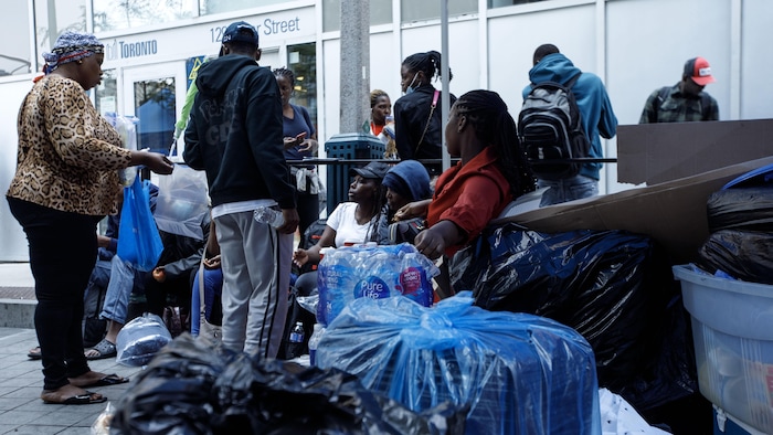 Des réfugiés devant un immeuble municipal au 129, rue Peter.