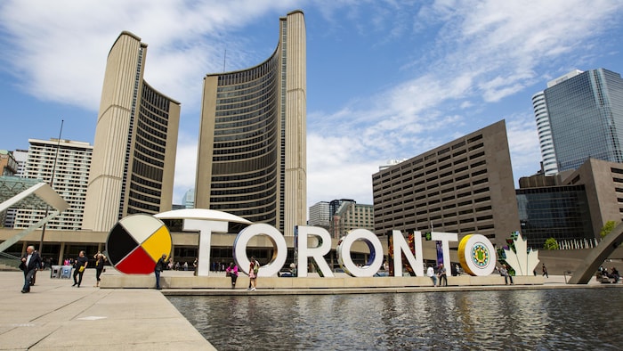Le sigle de Toronto devant les deux tours de l'hôtel de ville de Toronto.