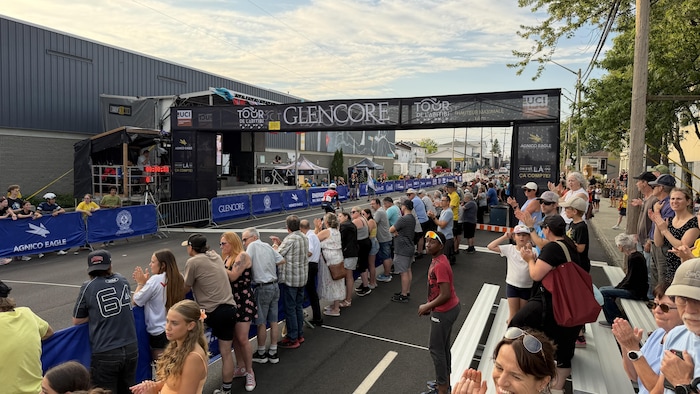 Une foule de spectateurs regarde l'arrivée des cyclistes sur l'avenue Dallaire lors du Tour de l'Abitibi.