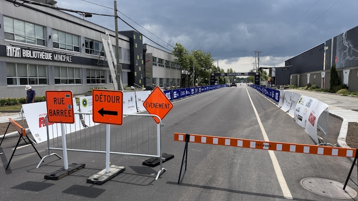 Des affiches et des barrières bloquant une portion de l'avenue Dallaire, à Rouyn-Noranda.