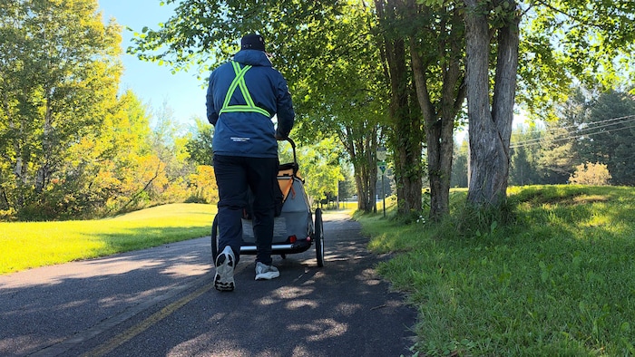 Un homme marche en poussant un chariot.