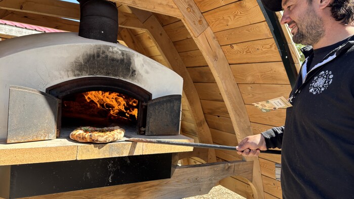 Un homme qui fait cuire une pizza