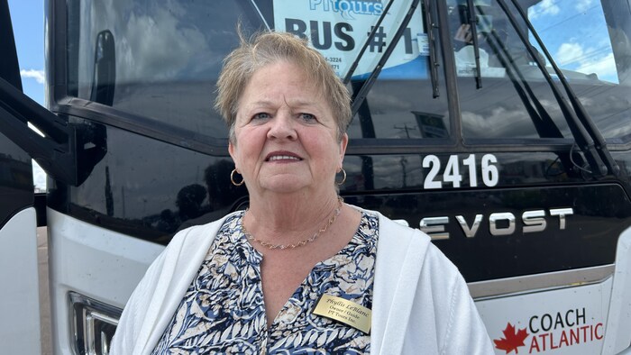 Une femme arrêtée devant un autobus. 