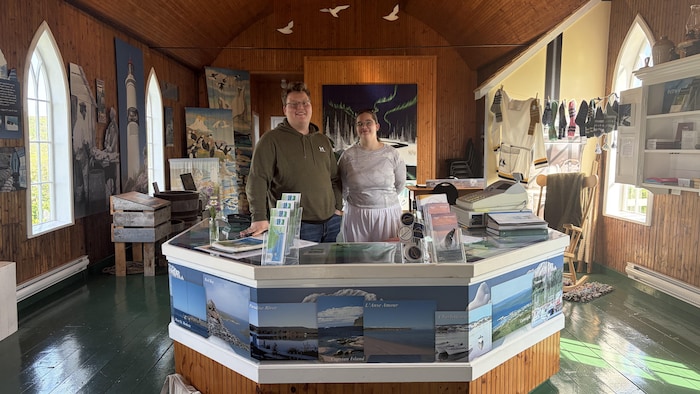 Deux employés d'un centre d'interprétation touristique posent devant la caméra.