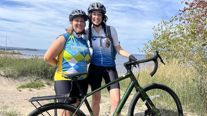 Deux femmes avec un vélo devant le lac Saint-Jean.