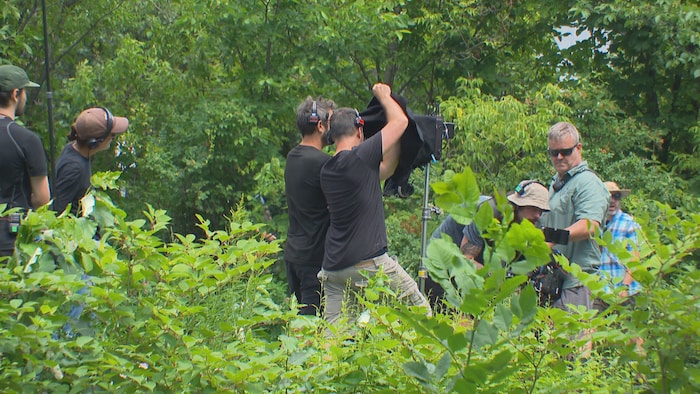 Une équipe de tournage à l'oeuvre sur un plateau extérieur, l'été.