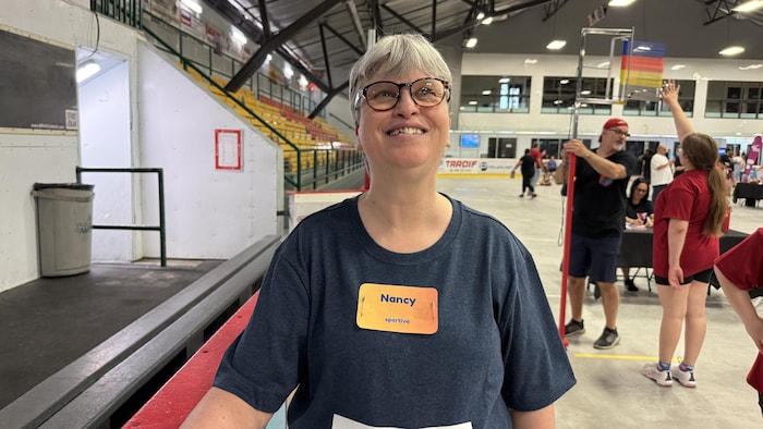 Nancy Langlois pose le bras accoté sur la bande d'une patinoire dans un aréna.
