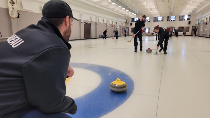 Des joueurs de curling s'affrontent sur la glace.