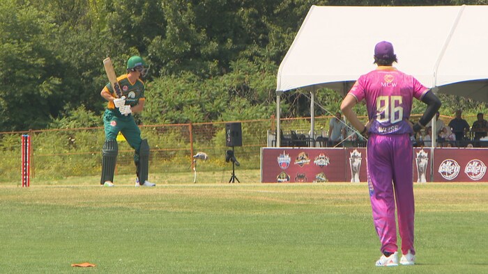 Un joueur de cricket en position avec une batte.