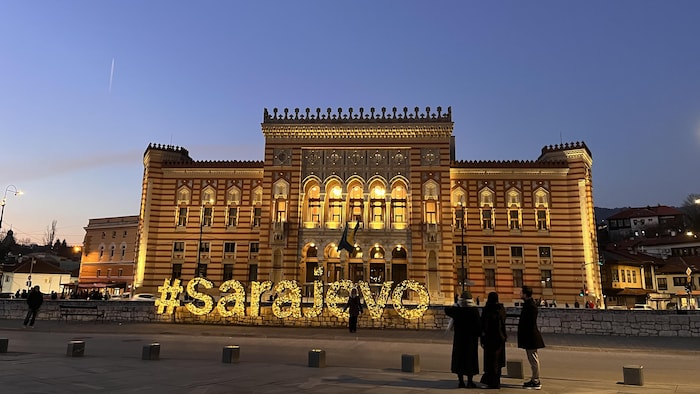 Grand bâtiment éclairé la nuit.