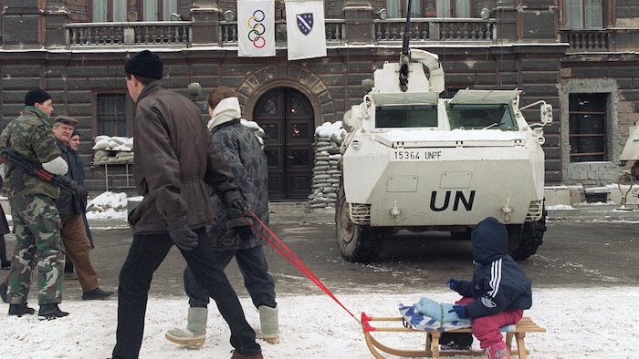 Deux Bosniaques tirent un enfant sur une luge le 16 février 1994 à Sarajevo.