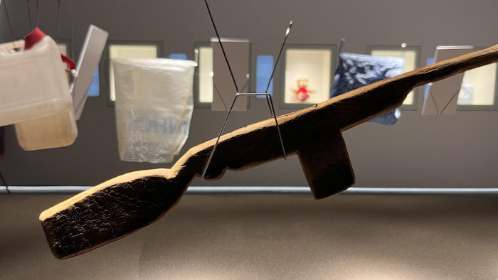 Un fusil en bois et des bidons pour aller chercher de l'eau.