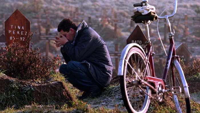 Le 19 décembre 1995, Stevo Pekez, un père en deuil, se recueille sur la tombe de sa fille Tina, 11 ans, tuée lors d'un bombardement alors qu'elle jouait à l'extérieur de sa maison.