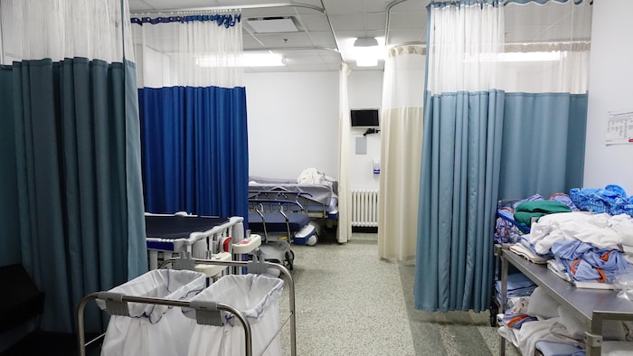 Rideaux bleus, paniers à linge et chariot avec jaquettes pliées.