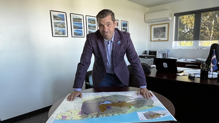 Le préfet de la MRC de la Haute-Gaspésie Guy Bernatchez debout devant la carte.