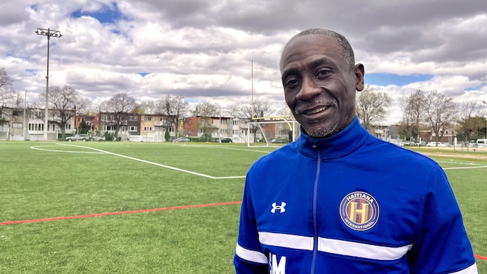 L'entraîneur Stanley Moiseau, devant un terrain de soccer.